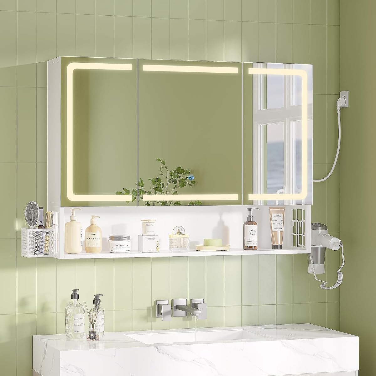 Armoire de toilette murale avec trois portes miroir, éclairage LED et étagère ouverte au-dessus d’une vasque.