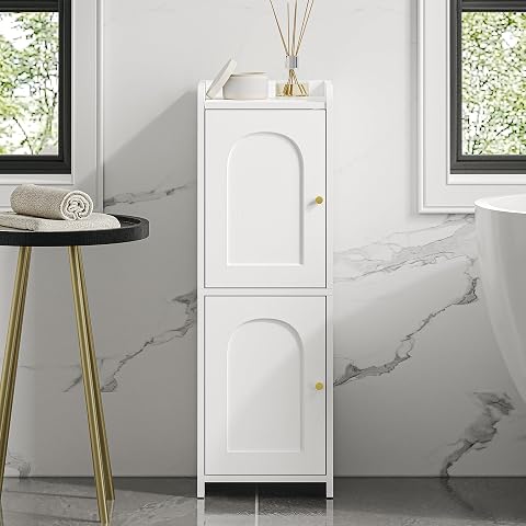 Armoire blanche étroite à deux portes cintrées installée dans l’angle d’une salle de bain lumineuse.