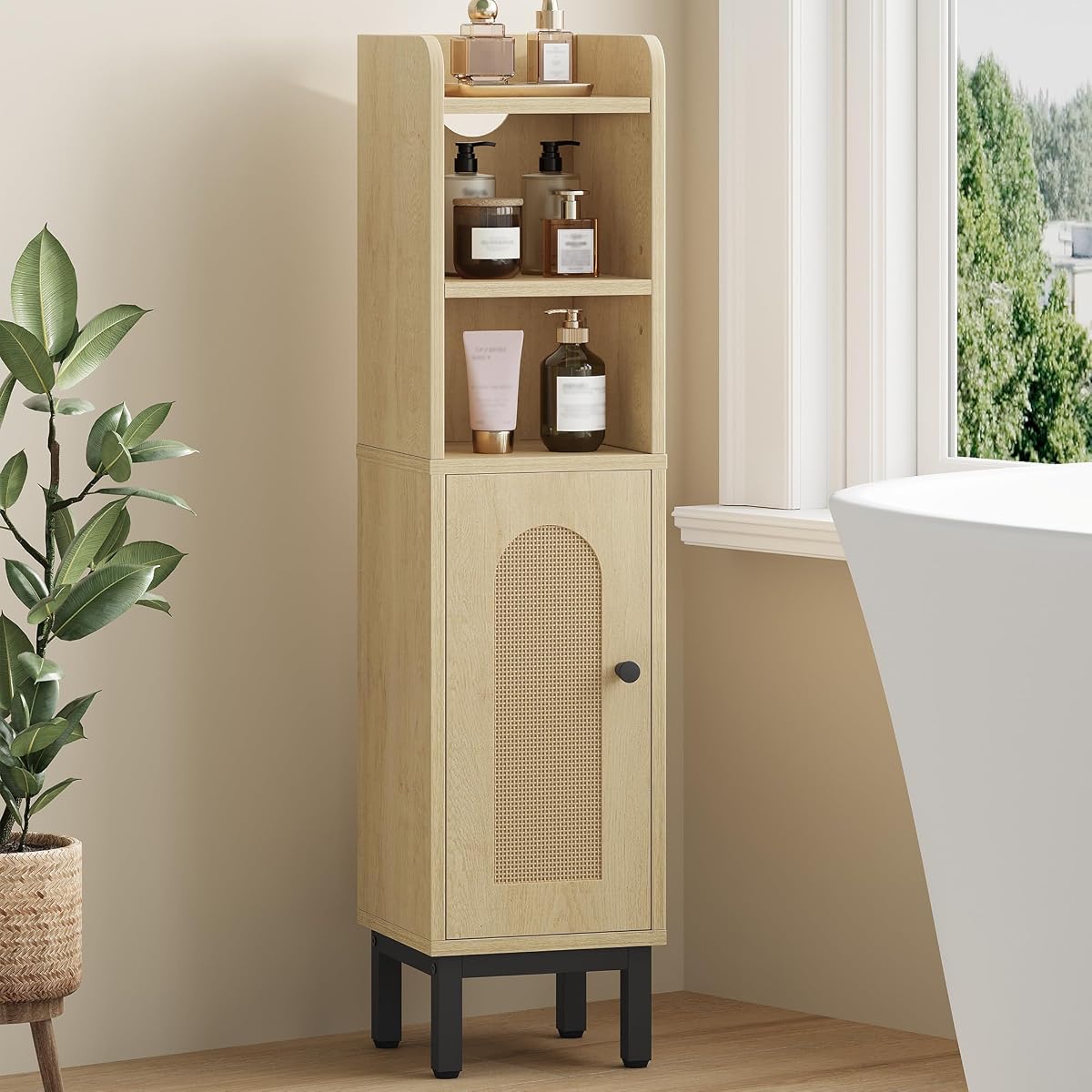 Armoire basse étroite en chêne clair, porte cintrée et pieds dorés dans une salle de bain lumineuse.